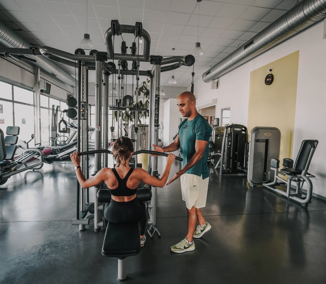 Coaching personnalisé sur machine de musculation dans une salle moderne et lumineuse